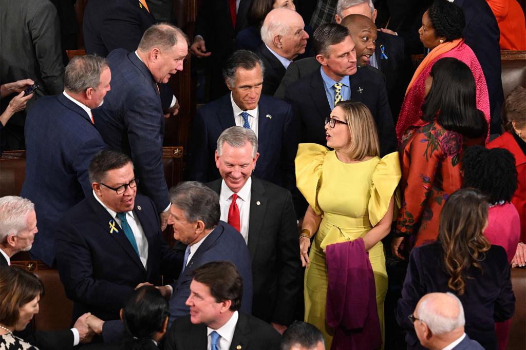 US Senator Kyrsten Sinema (C-R), (I-AZ), and Senator Mitt Romney (C L blue tie) (R-UT) arrive for President Joe Biden's State of the Union speech in Washington, DC, on Feb. 7, 2023.