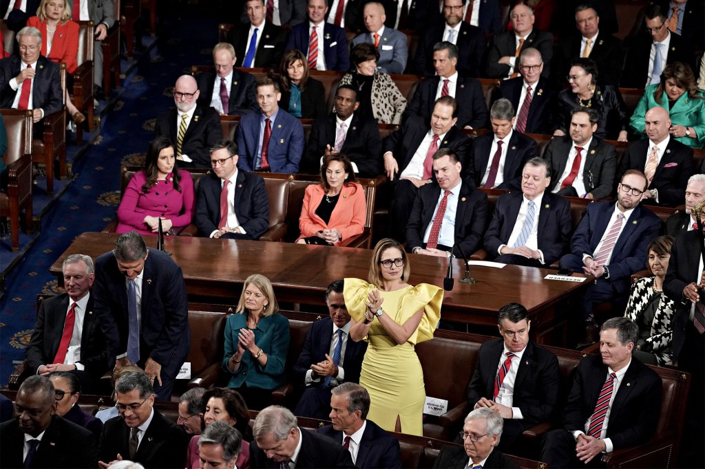 Senator Kyrsten Sinema stands and applauds during the State of the Union address at the US Capitol in Washington, DC on Feb. 7, 2023. 