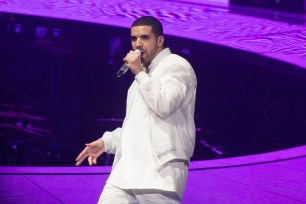 Drake performs onstage with a mic in hand.