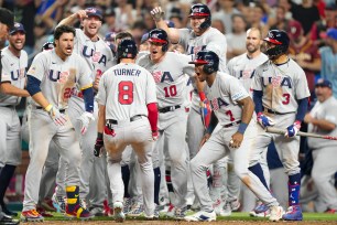 Trea Turner is mobbed by teammates after his grand slam homer propelled the United States to a win over Venezuela in the quarterfinals of the World Baseball Classic.