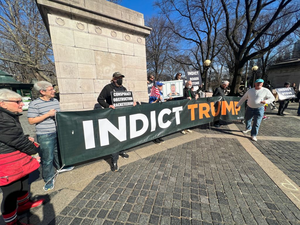 Photo of protesters holding an "indict trump" sign