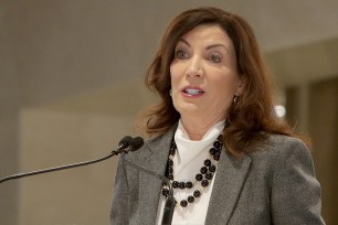 Hochul speaking at a podium with a microphone with a blurry background