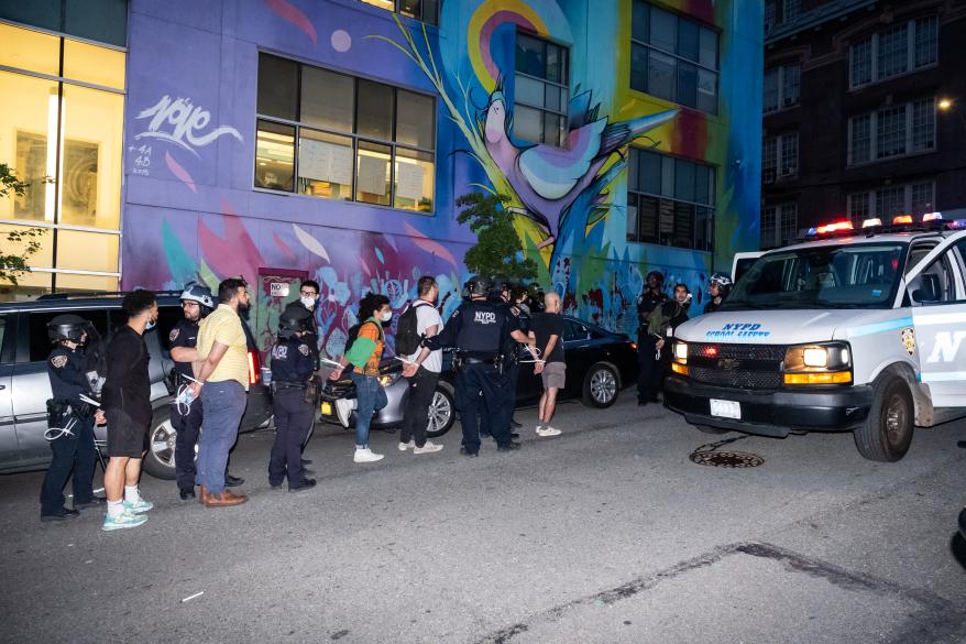 Arrested protestors lined up in police custody.