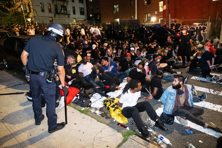 An NYPD cop with a group of the arrested protestors.