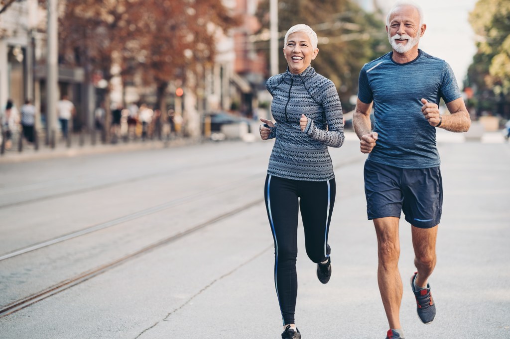 Couple of seniors jogging outdoors in the city