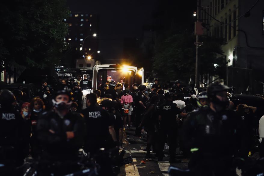 Police putting arrested protesters in a van.