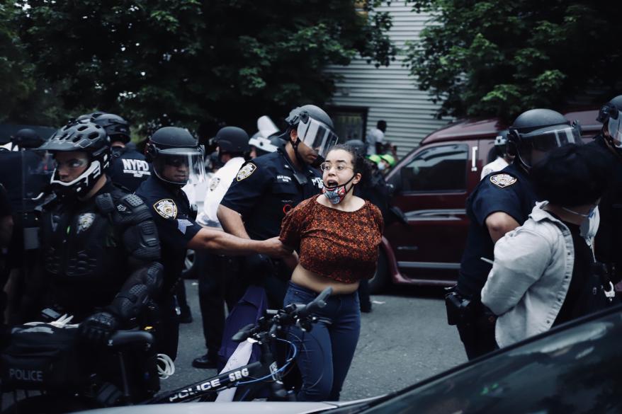 Cops taking a woman away in handcuffs from the protest.