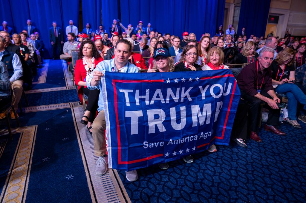 Supporters hold a flag as former President Donald Trump speaks at CPAC.