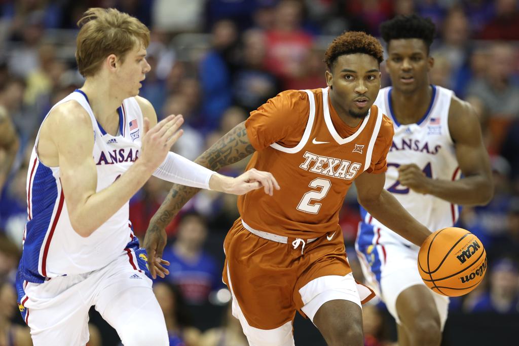 Arterio Morris of the Texas Longhorns drives to the basket against Gradey Dick of the Kansas Jayhawks during second half of the Big 12 Tournament Championship game.