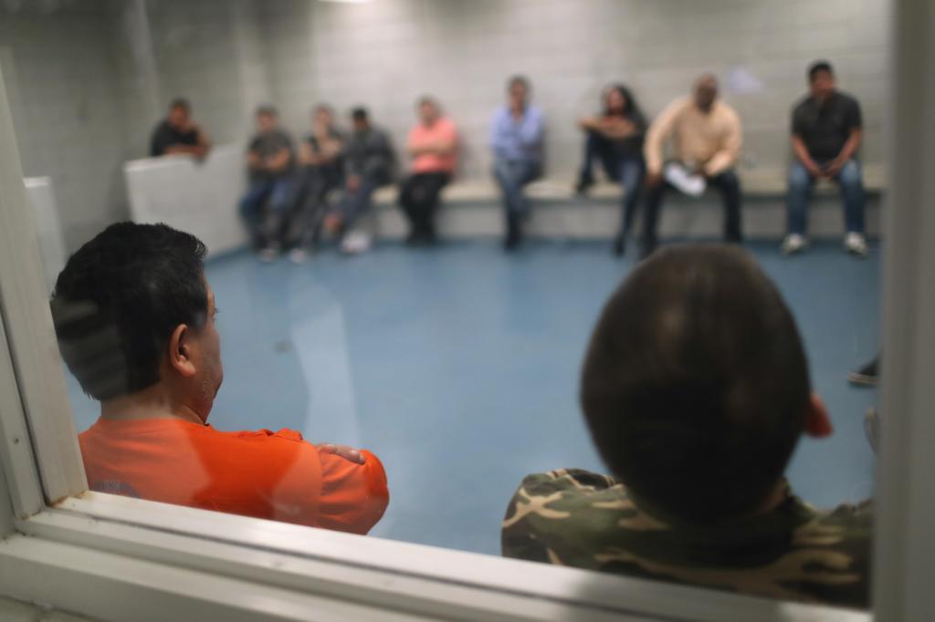 Undocumented immigrants wait in an Immigration and Customs Enforcement (ICE), processing center after they were arrested on April 11, 2018.