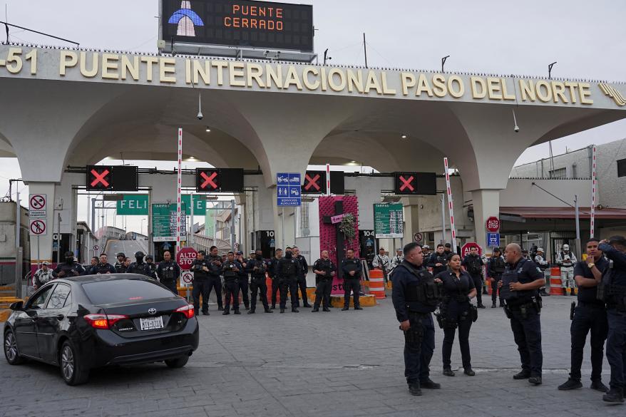 Mexican police stand guard in front of the entrance to the Paso del Norte International Bridge.