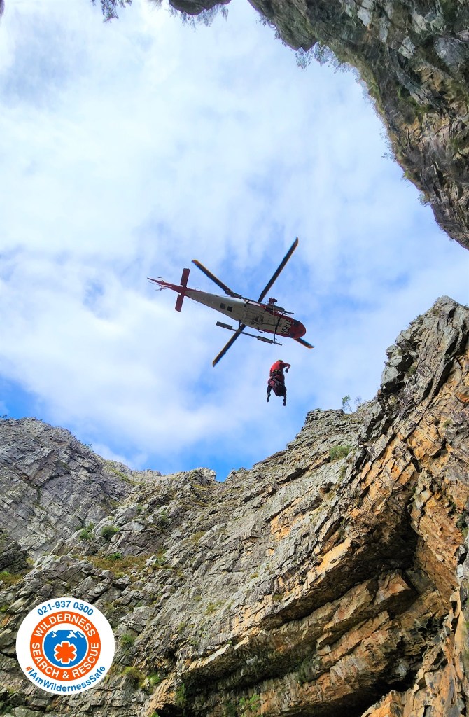 A helicopter airlifts one of the injured hikers to safety.