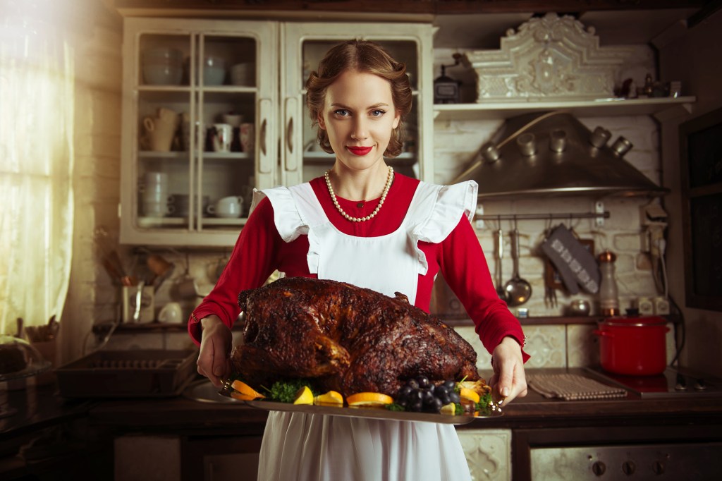 woman holding cooked turkey