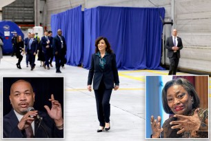 Hochul walking in a big room with a white tiled floor with blue curtains in background with a photo of Andrea Stewart-Cousins in bottom left and Carl Heastie in bottom right