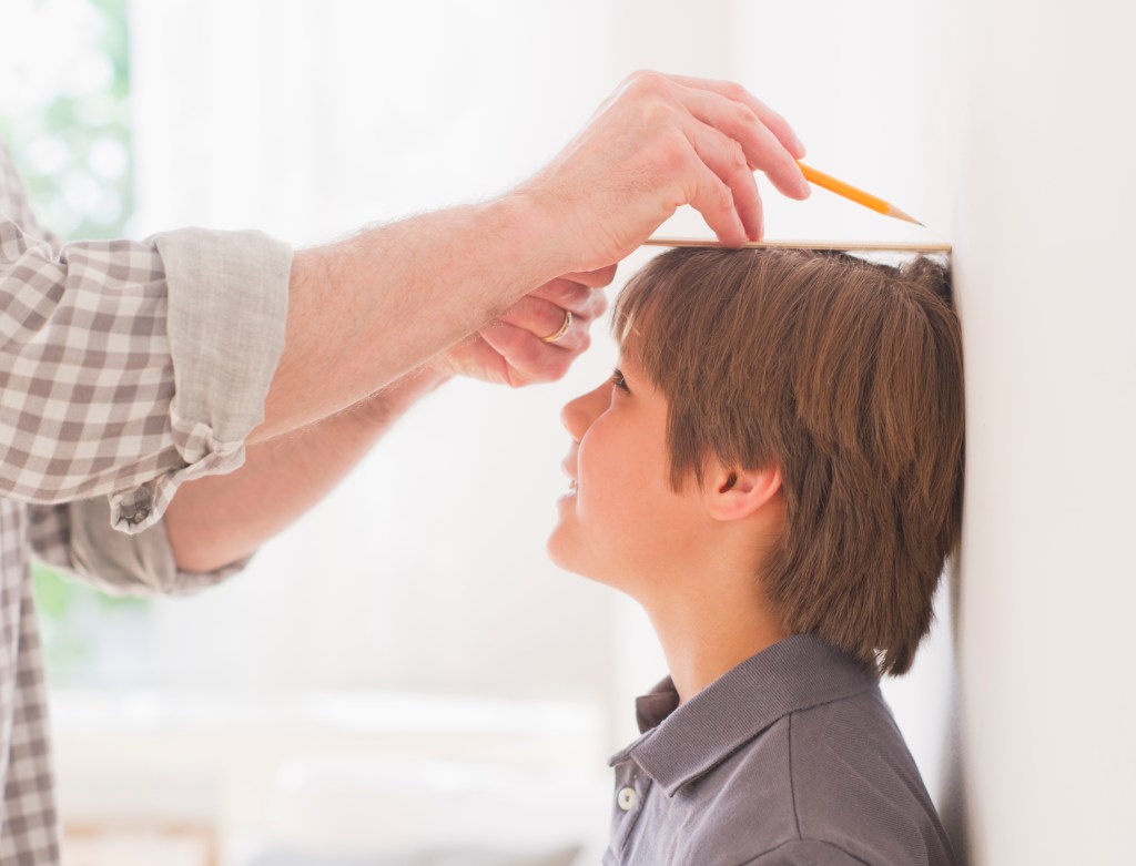 Child getting measured for his height.