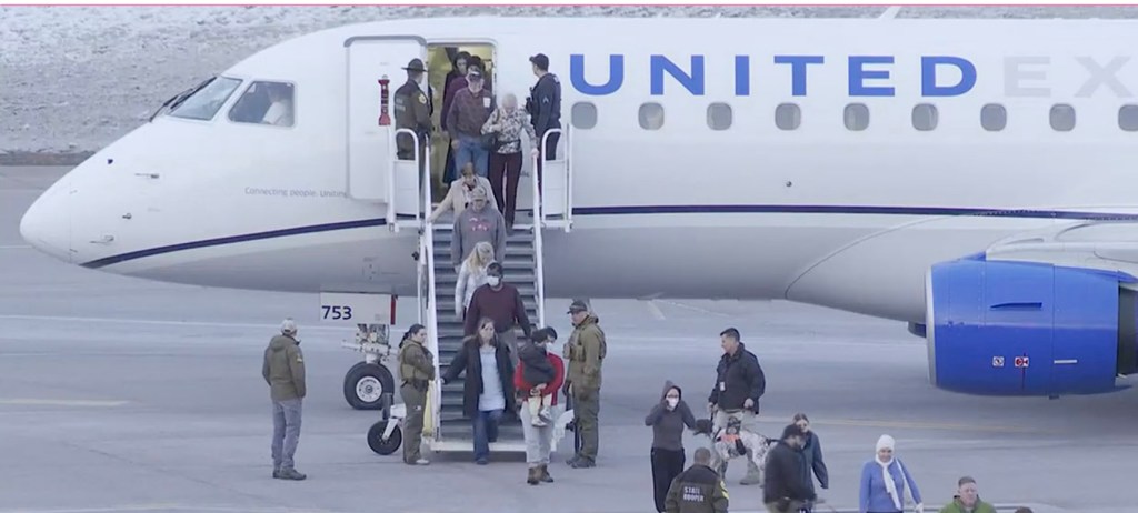 Passengers being removed from a United flight after a threat was discovered 