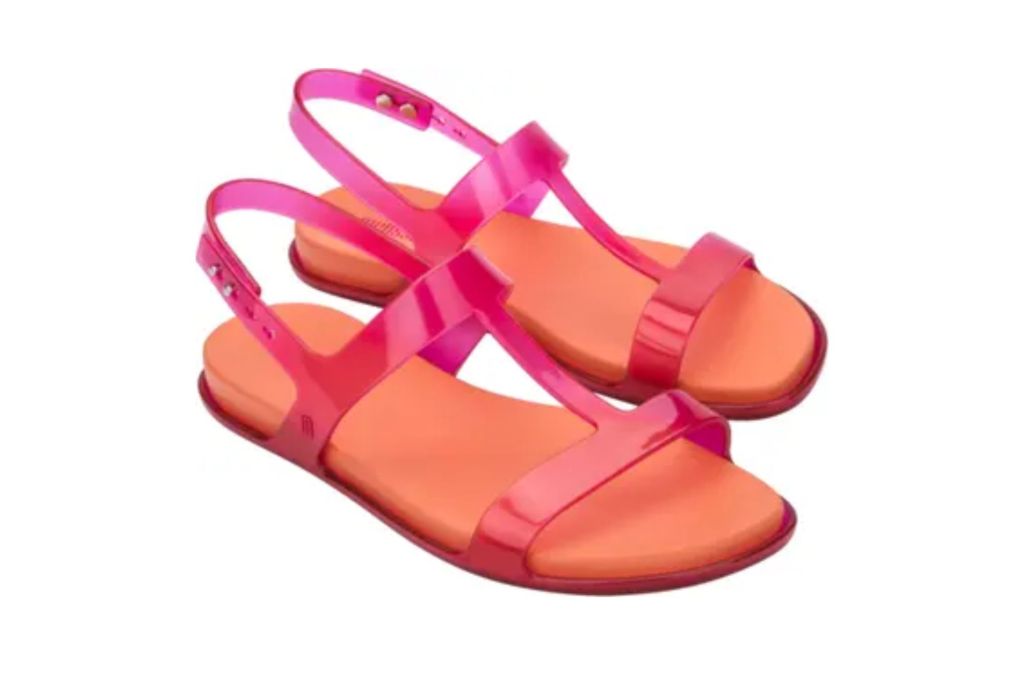 A pair of jelly sandals in the color orange and pink.
