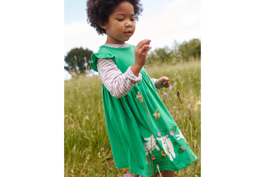 young girl in green dress in grassy field