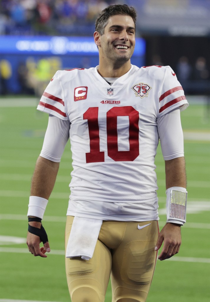 49ers quarterback Jimmy Garoppolo smiles on the field following a win over the Rams in January 2022.