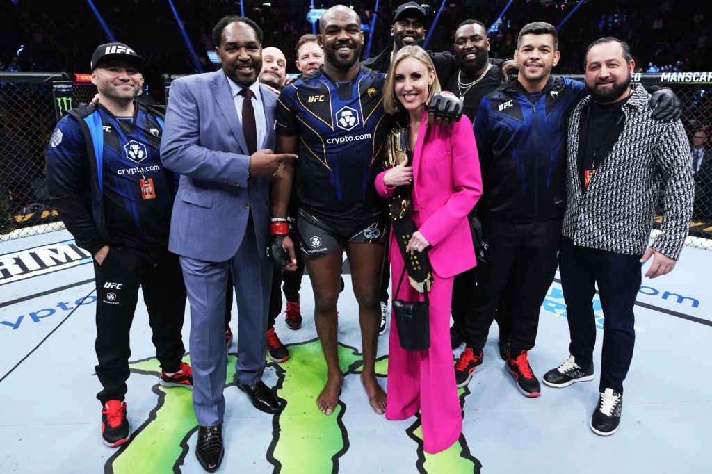 Jon Jones (c.) with his fiancée Jessie Moses (pink) and his entourage after defeating Ciryl Gane at UFC 285 on Saturday.