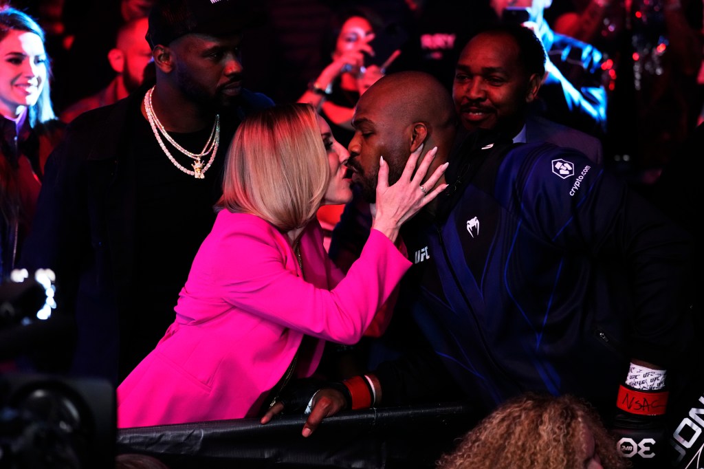 Jon Jones kisses his fiancée Jessie Moses as he enters the octagon at UFC 285 on Saturday.