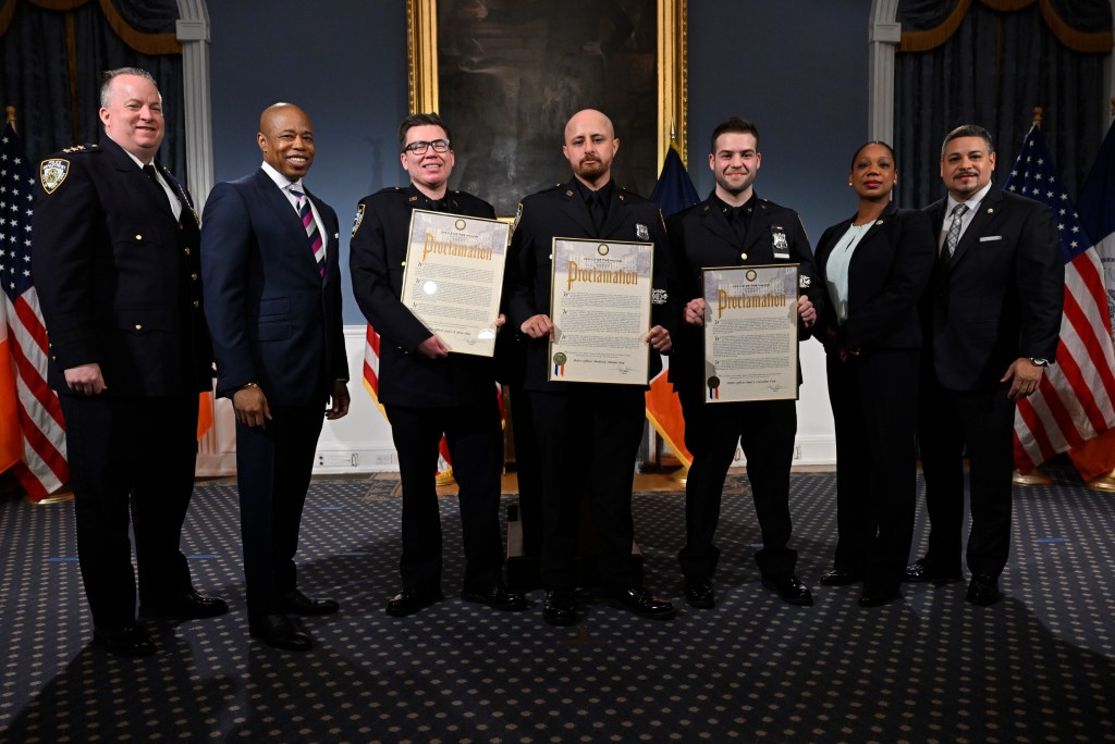 Left to right: NYPD Chief of Patrol John Schell, NYC Mayor Eric Adams, Officer Louis Iorio, Officer Paul Cozzolino and officer Mickel Hanna, New YorkCity Police Commissioner Keechant Sewell and First Deputy Police Commissioner Edward Caban.