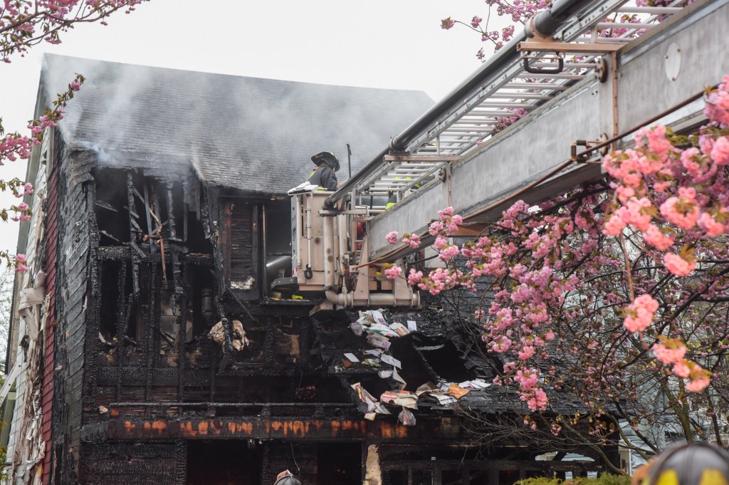 Firefighters in a cherry picker trying to knock down the three-alarm blaze.