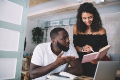 Couple smiles while reviewing finances and paying off debt