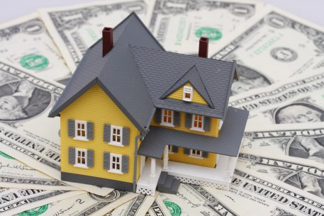 A model of a house surrounded by cash