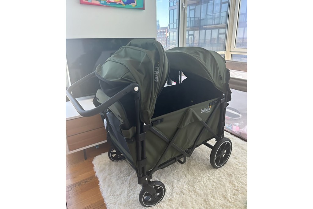 A green baby stroller in a room