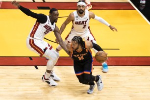 Jalen Brunson dribbles away from Bam Adebayo (left) and Gabe Vincent during the Knicks' Game 4 loss in Miami.