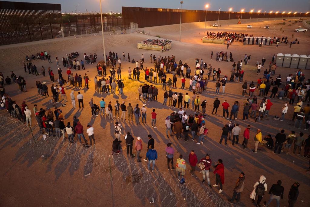 Migrants who crossed the U.S.-Mexico border wait to be transported by U.S. Customs and Border Protection officers for processing on Thursday, May 11, 2023 in El Paso, Texas.