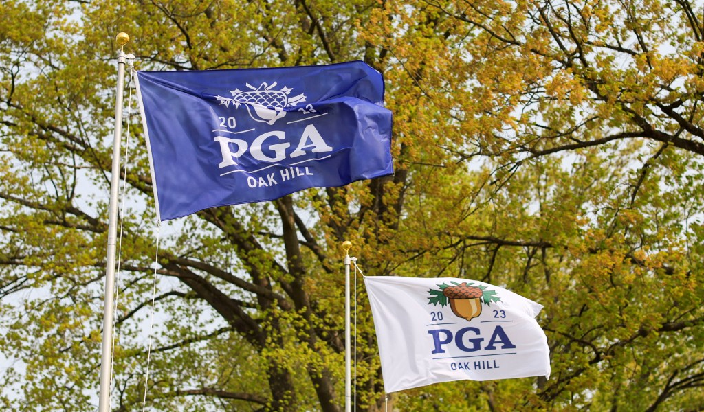 Winds whip the PGA Championship flags at Oak Hill golf course during a practice round. The first round is expected to be delayed due to frost.