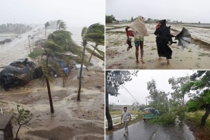 A family walks along with their goods during Cyclone Mocha's landfall at the Shahpori Dwip, Teknuf area near Cox's Bazar, Bangladesh, on May 14, 2023.