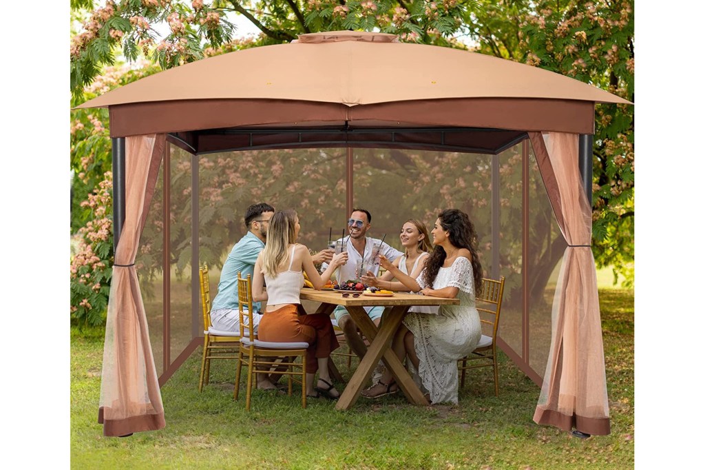 models sitting at table under brown round gazebo