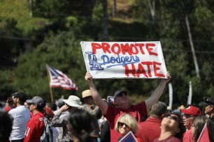 Protesters hold signs at a Catholics for Catholics event in response to the Dodgers' Pride Night event just before a game between the Los Angeles Dodgers and the San Francisco Giants at Dodger Stadium on June 16, 2023.