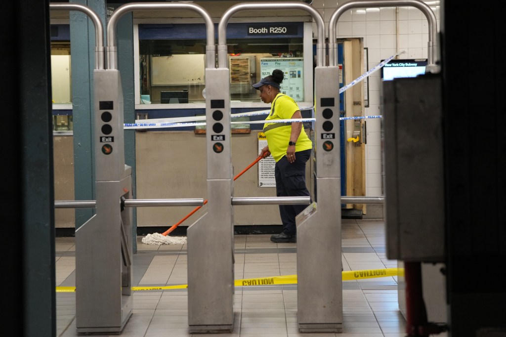 An employee mops the floor at the scene of a slashing at the East 86th and Lexington Avenue 