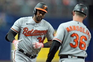 Aaron Hicks celebrates with third base coach Tony Mansolino after hitting a three-run homer in the first inning of the Orioles' 8-6 win over the Rays.