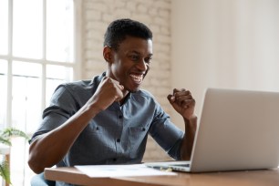 A young man celebrates lowering his student loan payment.