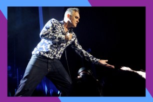 Morrissey reaches out to a fan while singing onstage.