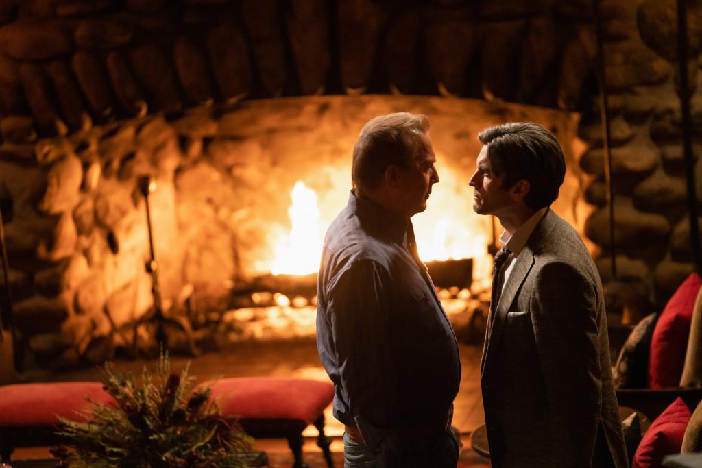 John Dutton (Kevin Costner) and his son Jamie (Wes Bentley) stand in front of a fire. 