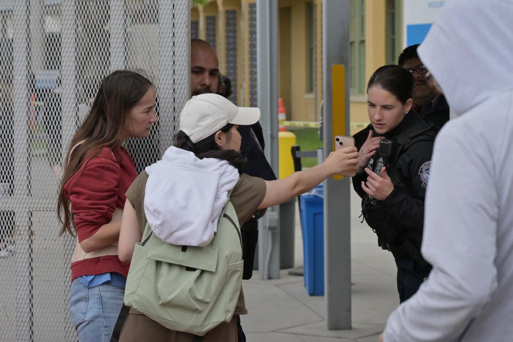 An asylum-seekers shows a US Customs and Border Protection officer her scheduled appointment through the CBP One App at the San Ysidro Port of Entry near San Diego, Cali. 