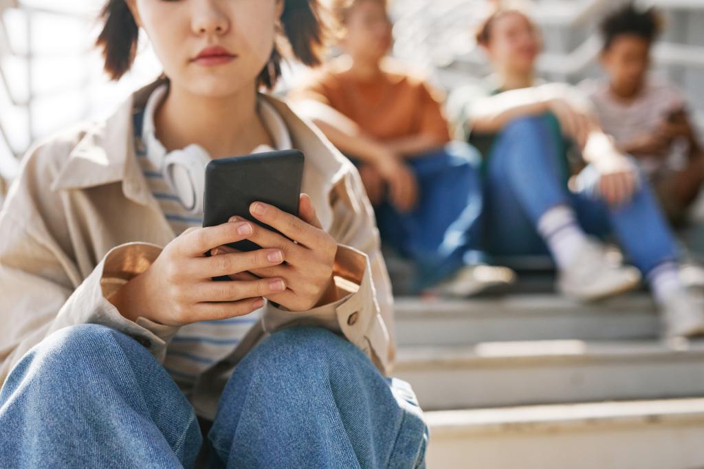 Teen on their phone sitting on stairs