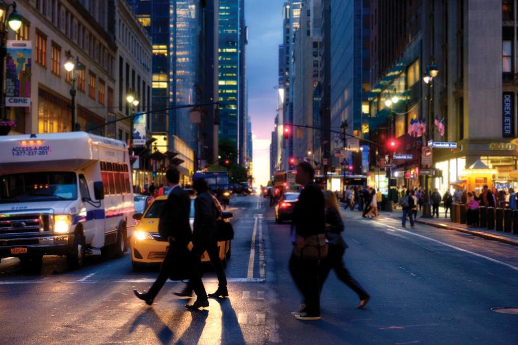 People walking New York City street at night
