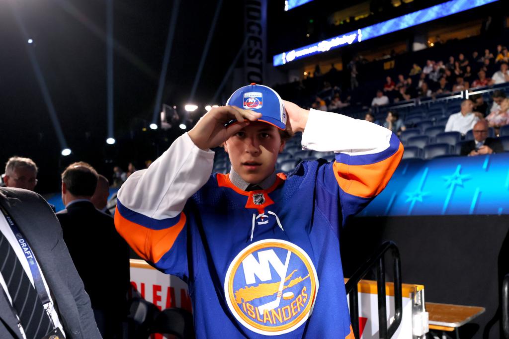 Zachary Schulz puts on an Islanders hat after being selected in the 2023 NHL Draft.