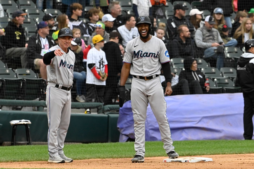 Miami Marlins left fielder Bryan De La Cruz (14) yells with Miami Marlins third base/infield coach Jody Reed.