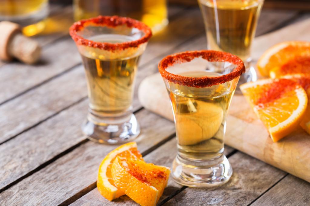 Mexican mezcal or mescal shot with chili pepper and orange