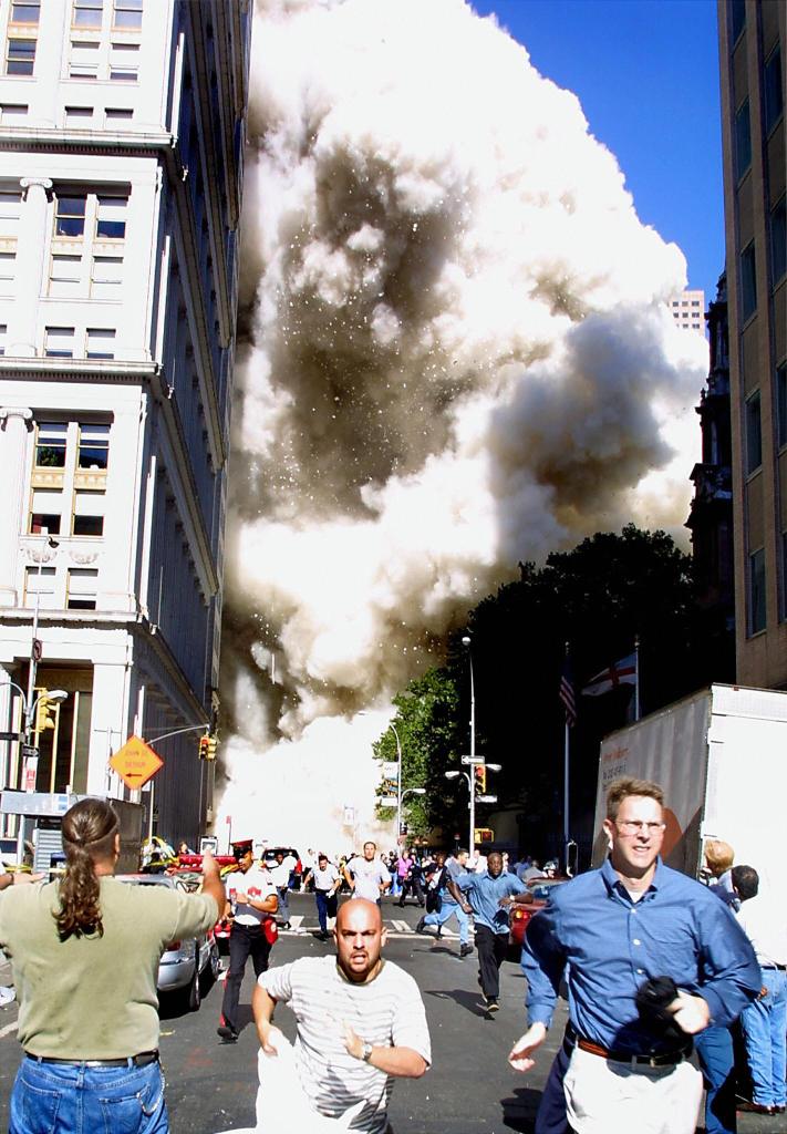 Pedestrians were pictured running away as the Twin Towers were collapsing in NYC.