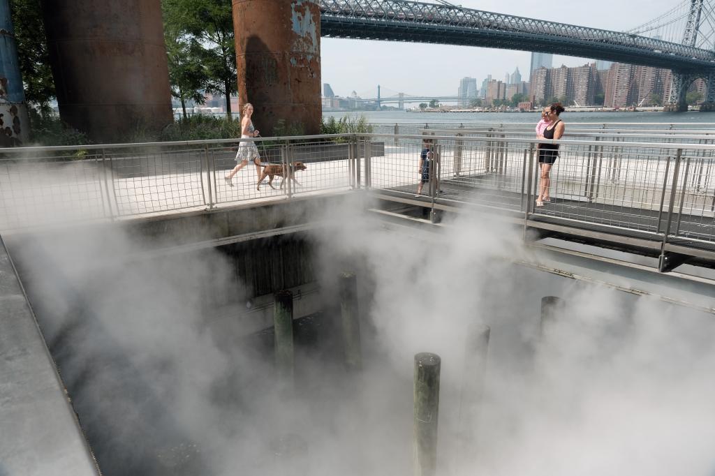 People try to keep cool at a misting site near the Manhattan Bridge in Brooklyn.