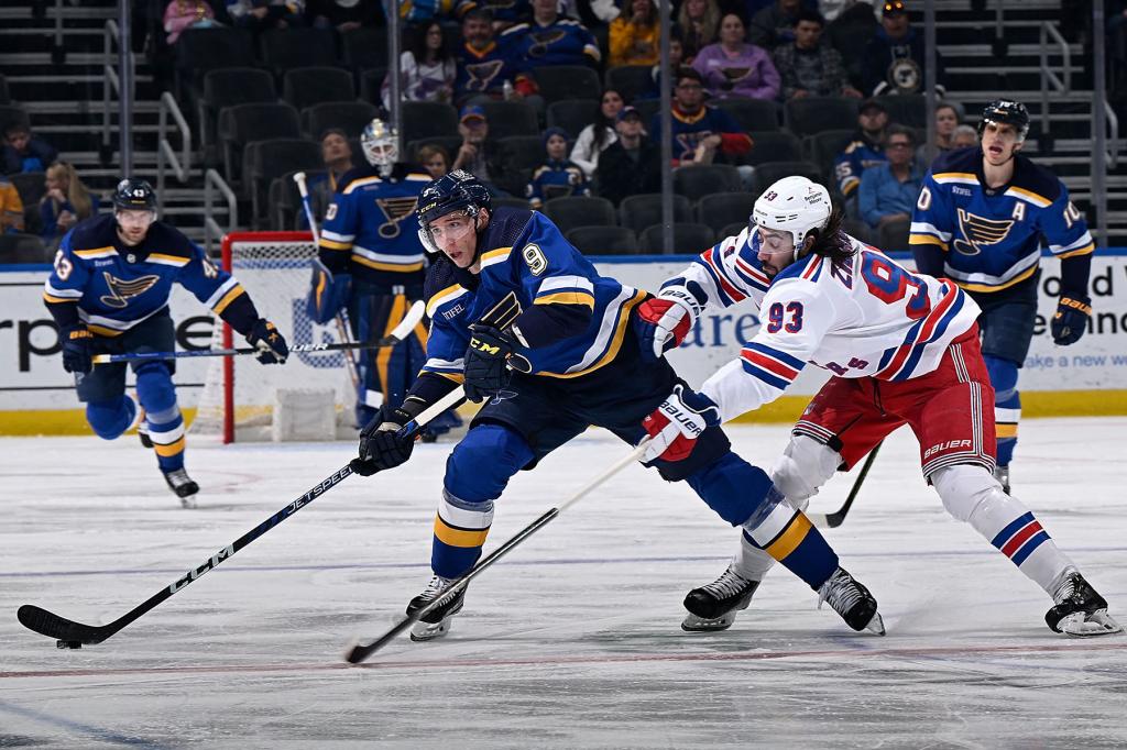 Tyler Pitlick #9 of the St. Louis Blues controls the puck as Mika Zibanejad #93 of the New York Rangers pressures at the Enterprise Center on April 6, 2023 in St. Louis, Missouri. 